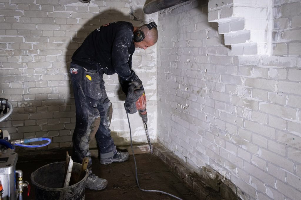 Vochtstop medewerker aan het werk met injectietechniek in een kelder